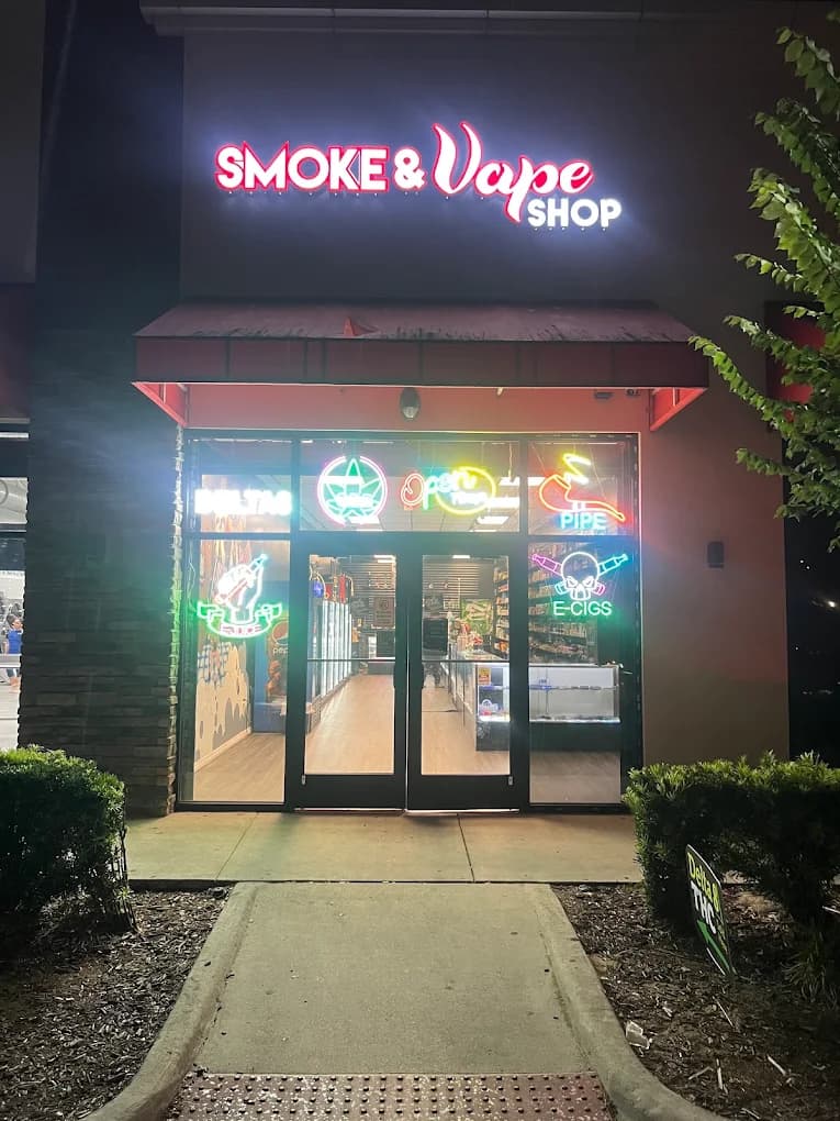 The Clarcona Ocoee shop after dark, its lit sign glowing above the entrance.
