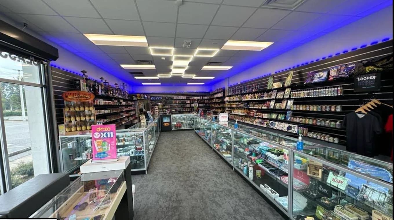 Inside the Orange Blossom Trail shop, looking down the aisle between glass counters to the back wall.