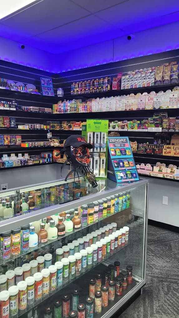 Inside the Kissimmee shop: shelves of vapes and wraps above a lit glass counter.